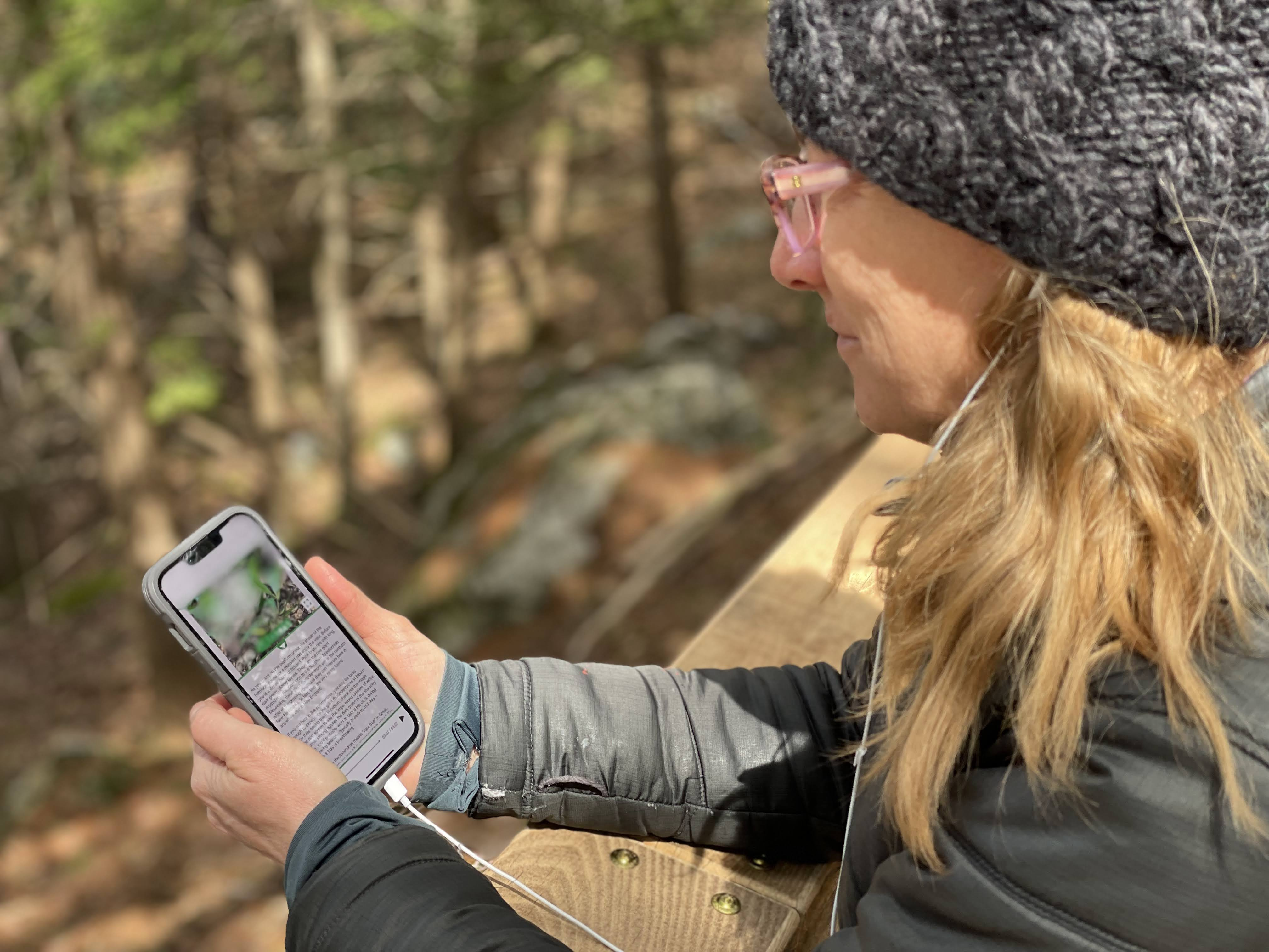 Person using phone on trail