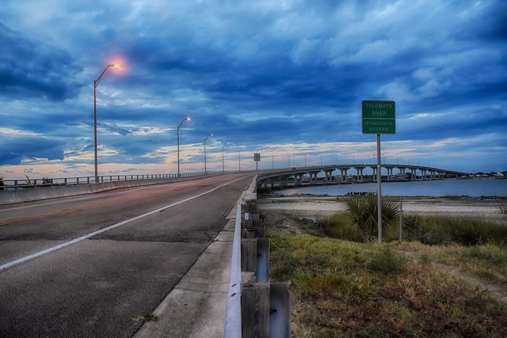 Scenic coastal roadway beneath a dramatic sky